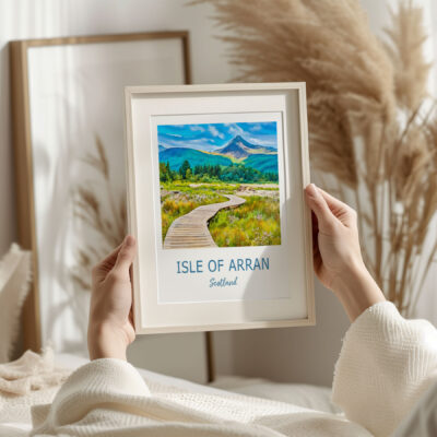 Hands holding Isle of Arran framed landscape artwork.