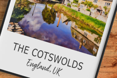 Reflection of Cotswolds village in water, England, UK.