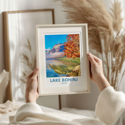 Person holding Lake Bohinj photo in cozy room.