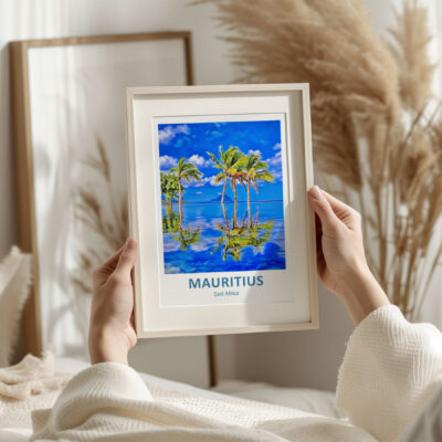 Person holding framed Mauritius beach artwork.